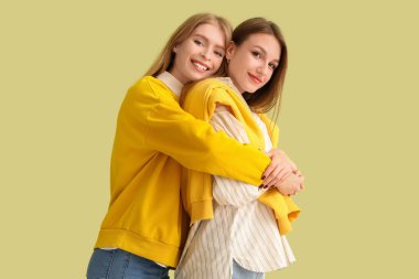 Yeşil arka planda sarılan genç kadınlar