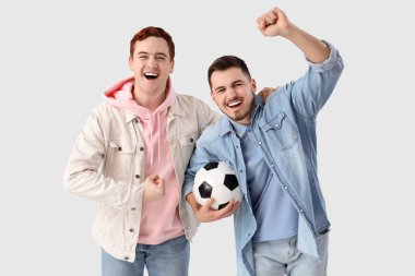 Futbol topuyla beyaz arka planda kucaklaşan erkek arkadaşlar