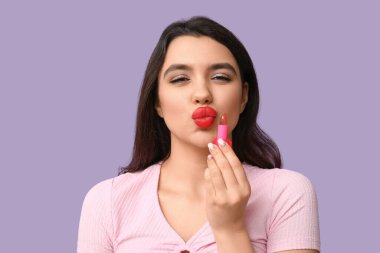 Leylak arkaplanda ruj izi olan güzel genç bir kadın.