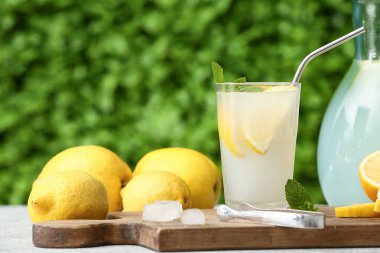 Dışarıdaki gri masada naneli bir bardak taze limonata.