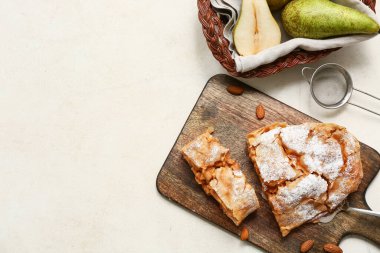 Lezzetli armutlu turta, taze meyve ve fındıklı bej arka planda ahşap tahta.