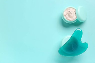 Turkuaz arka planda kozmetik ürünler ve yüz masajı araçları