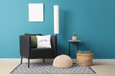 Standart lamba ve puf, mavi duvarın yanında.