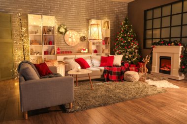 Oturma odasının içi yumuşak kanepe, raf üniteleri ve Noel kutlaması için hazırlanmış şömineyle dolu.