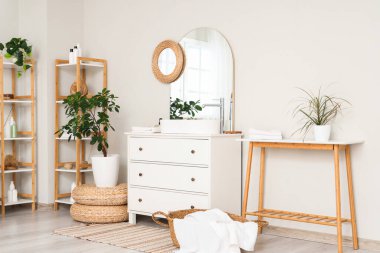 Lavabosu, çekmecesi ve beyaz duvarı olan şık bir banyonun içi.