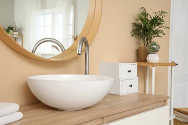 Modern lavabo ve masa başı çekmeceleri banyodaki ahşap masada.