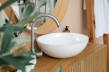 Modern lavabo kasesi banyodaki ahşap çekmecelerde.