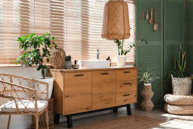 Modern lavabo, ahşap çekmeceler ve banyonun penceresinin yanındaki katlı ekran.