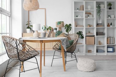 Büyük raf ünitesi, masa ve sandalyeleri olan modern bir oturma odası.