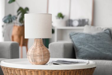 Oturma odasındaki kahve masasında dergileri olan lamba, yakın plan.