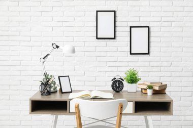 Şık masa, lamba, defter ve sandalye aydınlatma odasında.