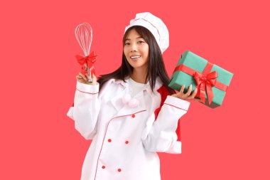 Hediye kutusu ve kırmızı arka planı olan Asyalı kadın şef.