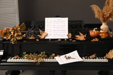 Sonbahar dekoru ve notaları olan bir piyano. Yakın çekim.