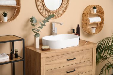 Beyaz seramik lavabo ve banyoda ahşap çekmeceler.