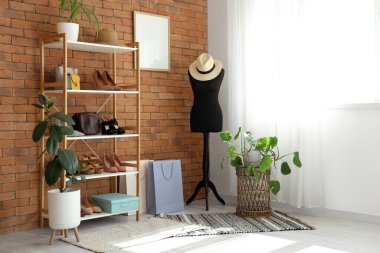 Manken, raf ünitesi ve ayakkabılarla dolu bir soyunma odası.