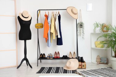 Manken ve elbise askısı olan açık renk soyunma odasının içinde.