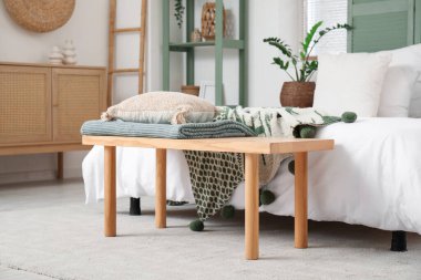 Yatak odasının iç tarafındaki rahat yatağın yanında yastıklı ve ekose banklı.