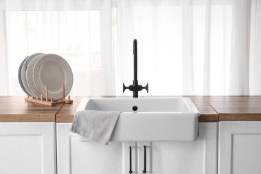 Güzel mutfağın penceresinin yanındaki ahşap tezgahta lavabo