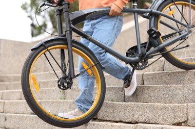 Bisikletli genç adam şehre iniyor, yakın plan.