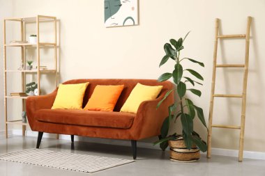 Çiçek, merdiven, kanepe ve raflar oturma odasının içinde.