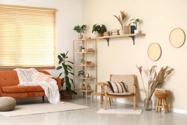 Oturma odasının içinde rahat bir kanepe, sandalye ve raf var.