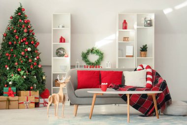 Konforlu kanepe, içkili kahve masası ve oturma odasının içinde Noel geyiği.