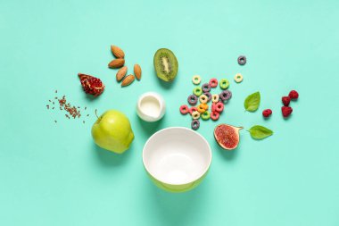 Mısır gevreği halkaları ve yeşil arka planda meyvelerle lezzetli bir kahvaltı.