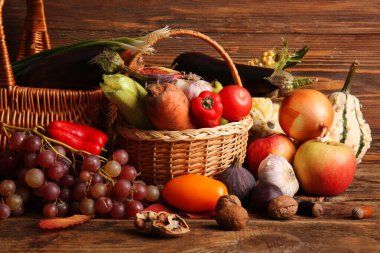 Taze sebzeli sepetler ve ahşap arka planda meyveler. Hasat festivali