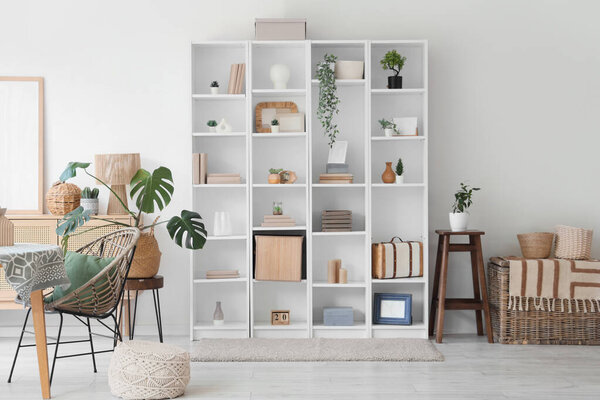 Interior of stylish modern living room with big shelving unit and houseplants