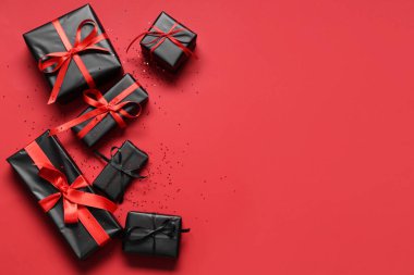 Kırmızı arka planda hediye kutuları. Kara Cuma indirimi. Üst görünüm