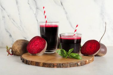 Beyaz arka planda fesleğenli ve sebzeli taze pancar suyu.