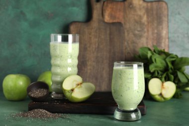 Yeşil arka planda elma ve chia tohumlu taze ıspanaklı smoothie.