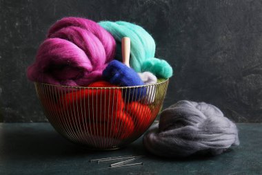 Kesecek farklı yün sepet ve koyu arkaplanda iğneler.