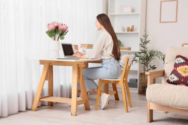 Odada güzel protea çiçekleriyle çalışan genç bir kadın.