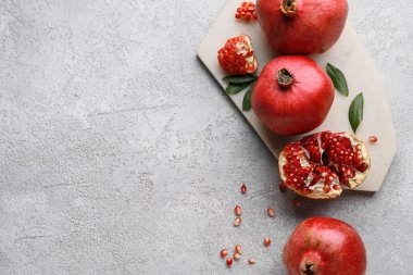 Taze olgun narı ve gri arka planda tohumları olan tahta.