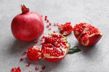 Gri zemin üzerinde tohumları olan taze olgun narlar.