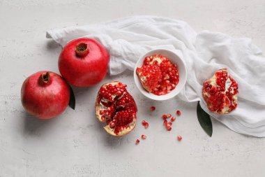 Taze olgun nar ve beyaz arka planda tohumlarla dolu bir kase.