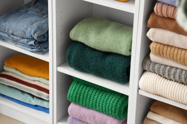 Soyunma odasındaki raflarda şık kıyafetler. Yakın çekim.