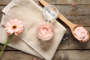 Doğal vücut fırçası, temiz havlu ve ahşap arka planda gerbera çiçeği olan kompozisyon