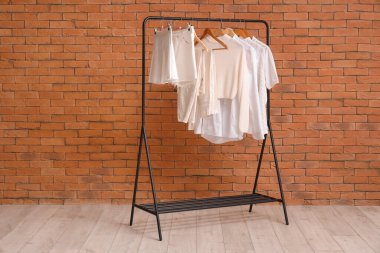 Tuğla duvarın yanında beyaz elbiselerle dizilin.