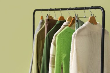 Yeşil duvarın yanında şık elbiselerle dizilin.