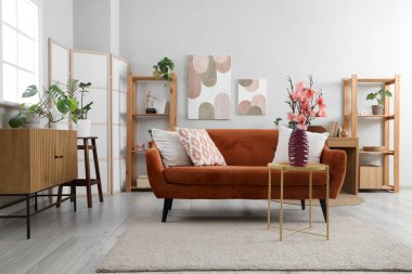 Oturma odasının içinde, sehpadaki vazoda manolya çiçekleri var.