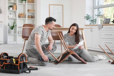 Mutfakta manuel montaj sandalyesi olan mutlu bir çift.