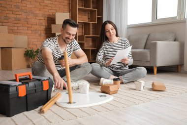 Taşındığı gün odada küçük bir masa kuran mutlu bir çift.