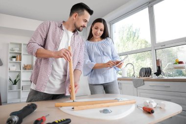 Mutlu hamile çift mutfak masasında toplanıyor.