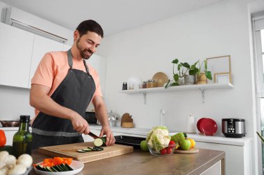 Mutfakta kabak kesen yakışıklı sakallı adam.