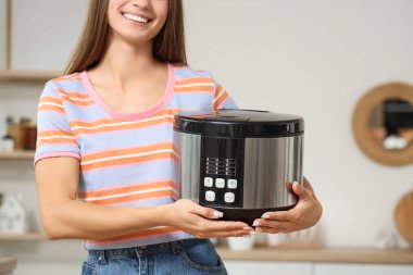 Mutfakta çoklu ocağı olan genç bir kadın, yakın plan.