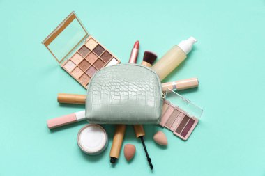 Kozmetik çantalı kompozisyon, makyaj ürünleri ve yeşil arka planda aksesuarlar