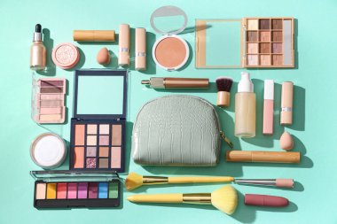 Kozmetik çantalı kompozisyon, makyaj ürünleri ve yeşil arka planda aksesuarlar