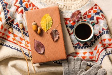 Kitaplar, bir fincan kahve ve şık, sıcak süveter üzerine sonbahar dekoru